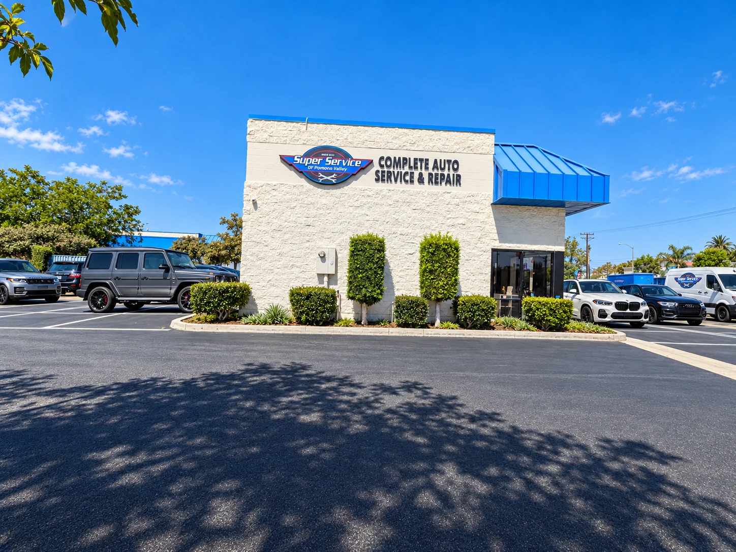 Super Service of Pomona Valley shop exterior with blue awning, business sign, and customer parking